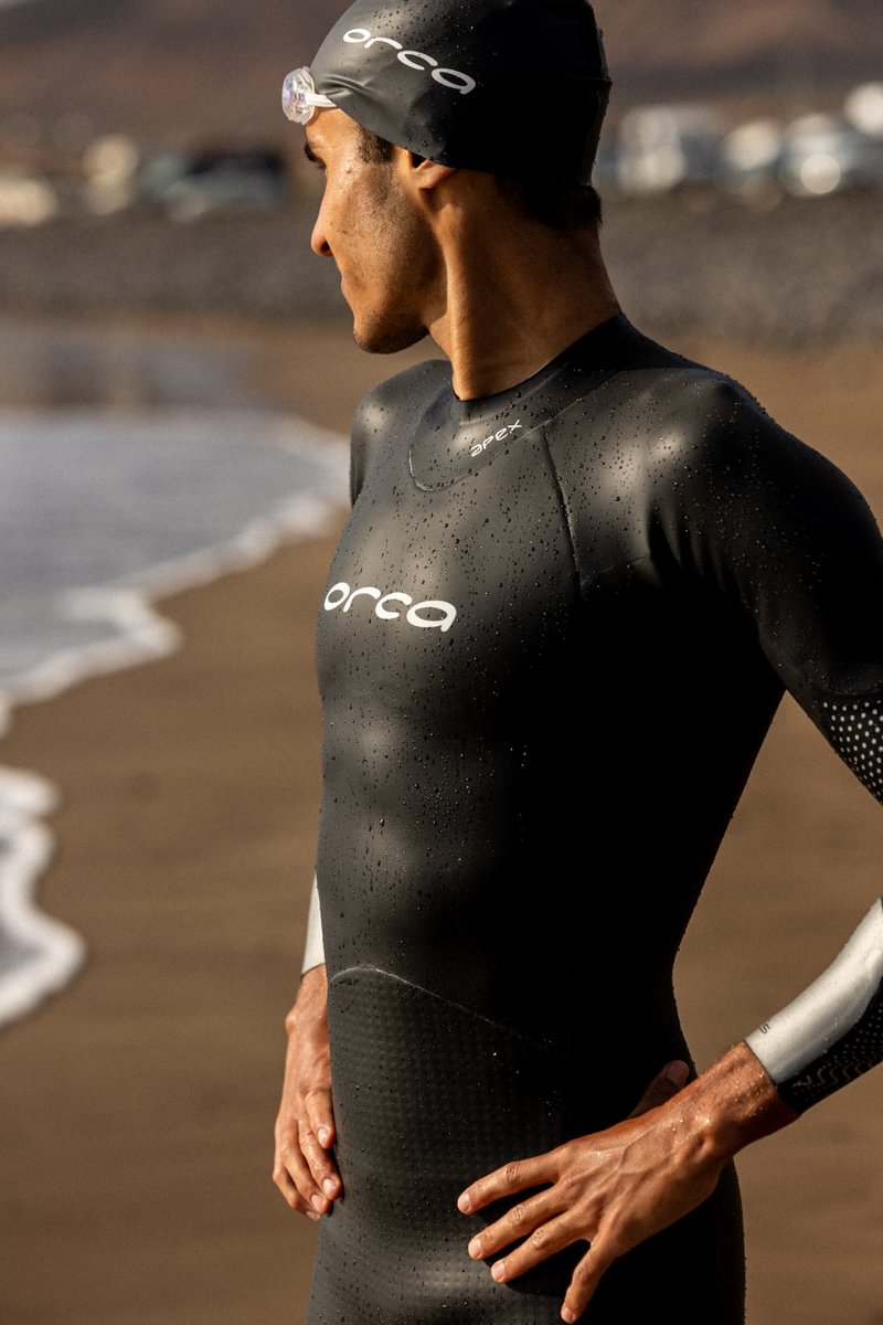 Man standing by sea in orca apex flow triathlon wetsuit