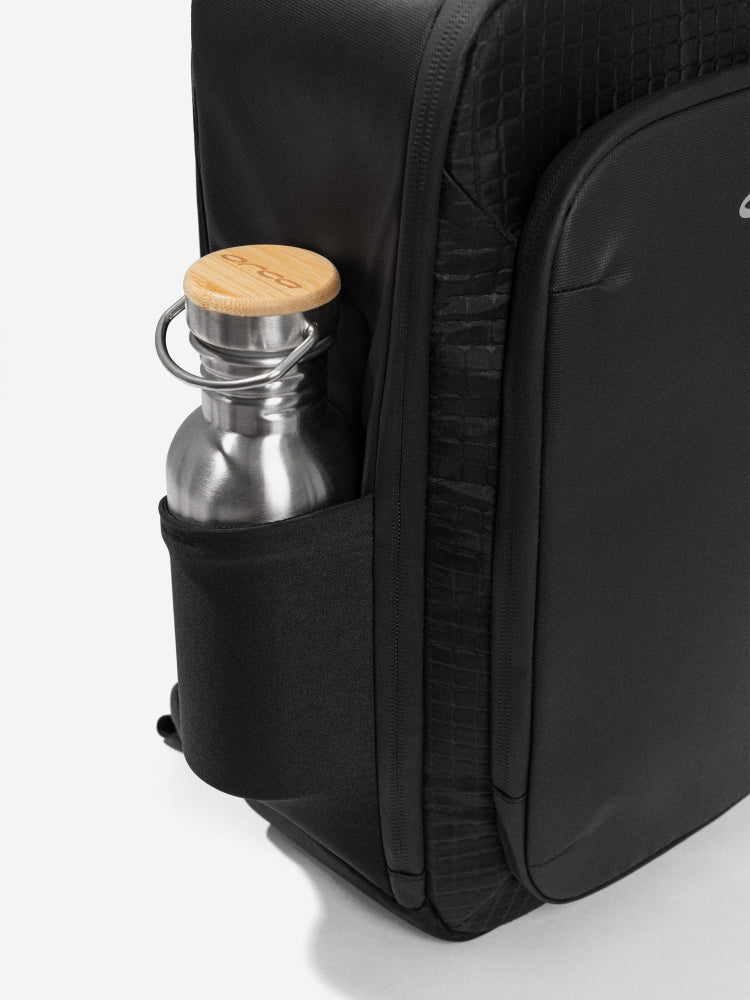 orca casual backpack in black, with soft and comfortable lower back support and space for a 15 inch laptop. Picture of side of backpack on white background.