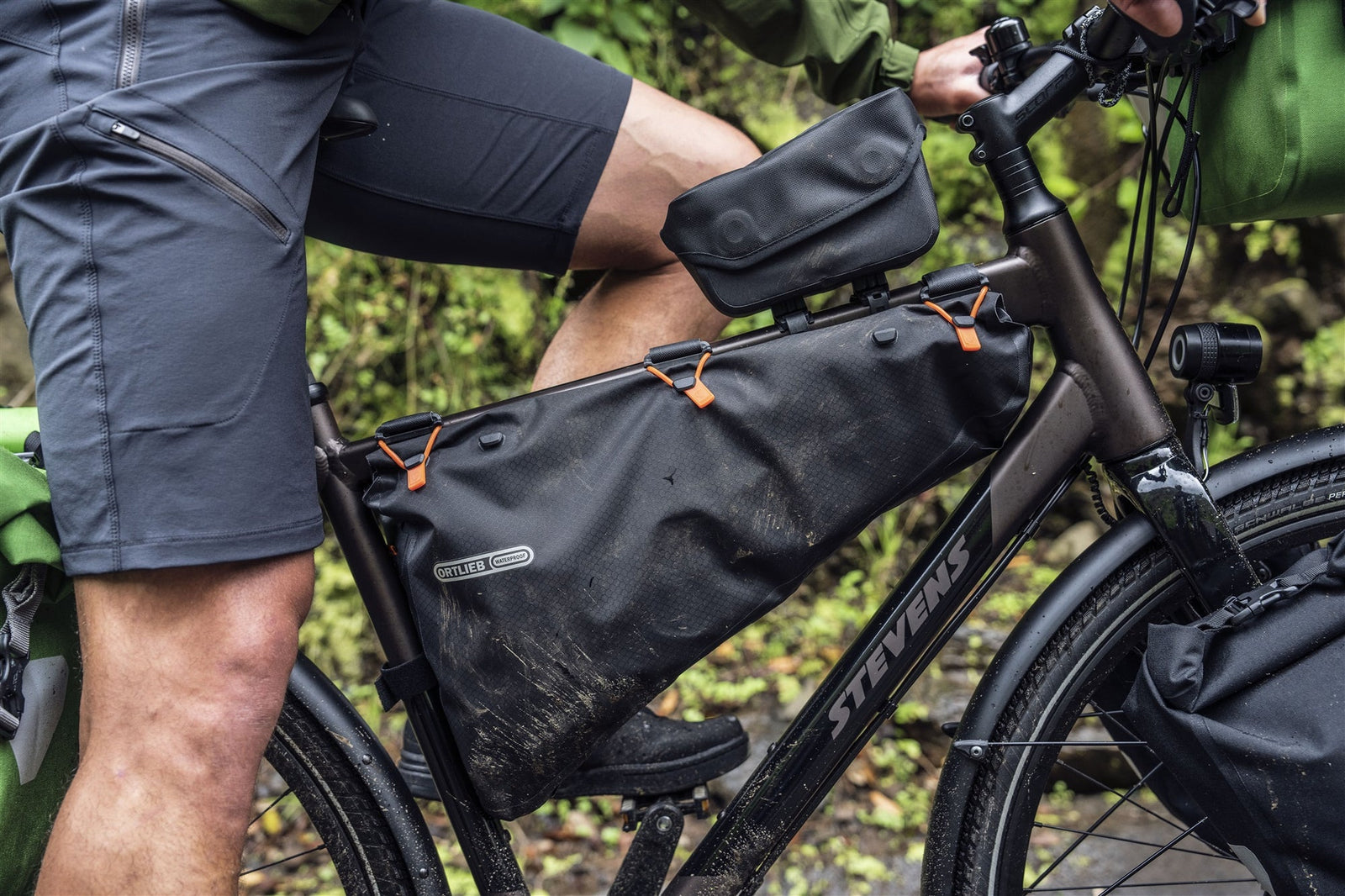 Person riding a bicycle showing Ortlieb top tube bags, waterproof bike bags