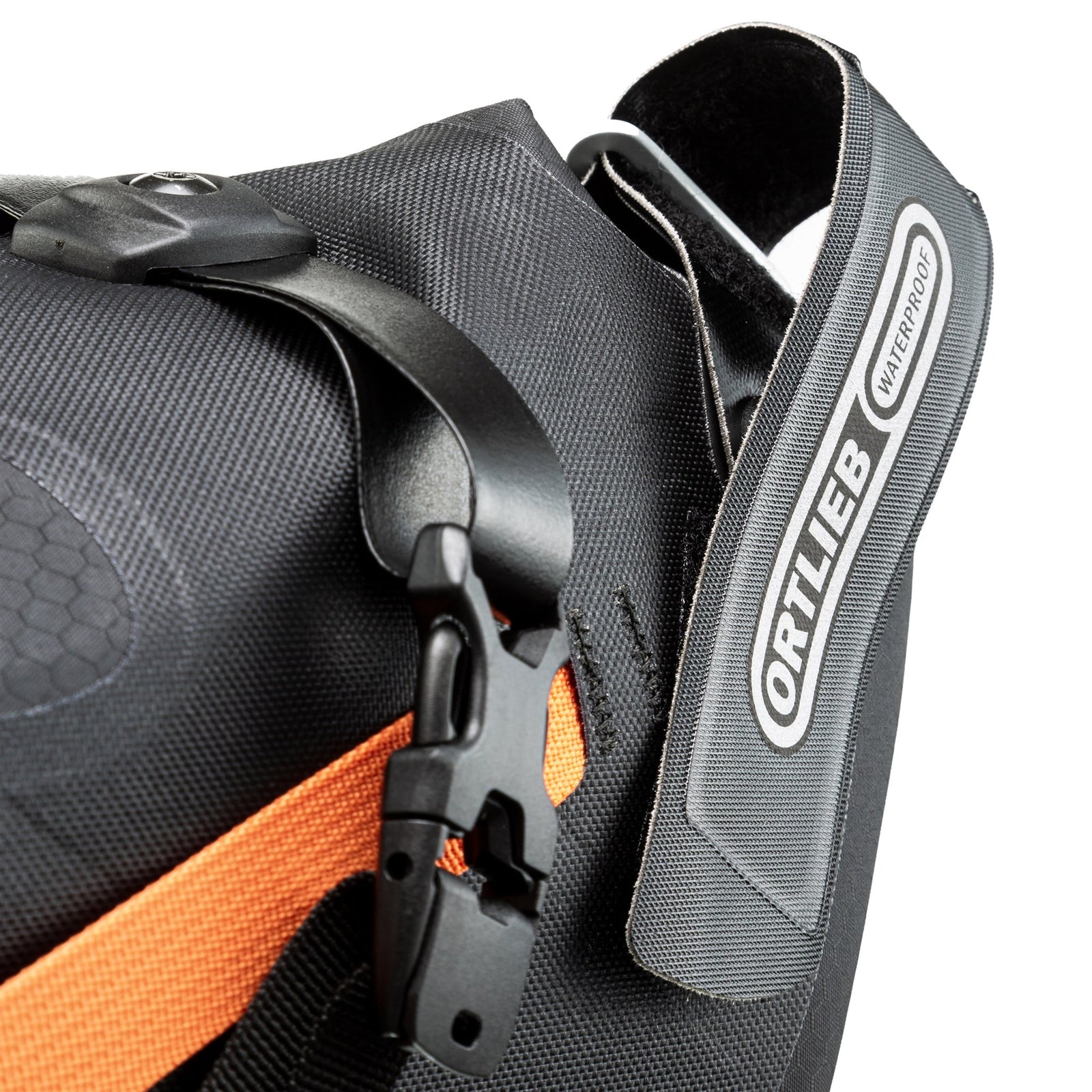 Close-up of a black and orange bag with 'Ortlieb' branding on a white background