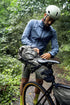 Person preparing a bike with a ortlieb seat bag in a forest setting