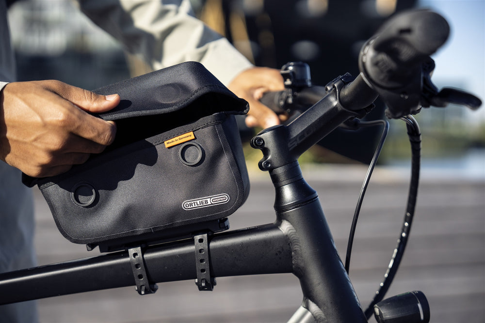 Person accessing the ortlieb top tube bag attached to bike frame
