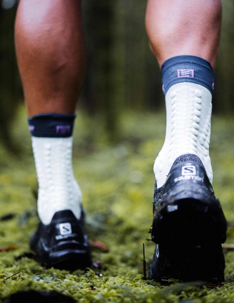 compressport pro racing trail socks, quarter length compression trail running sock, light turquoise with dark turquoise band and purple detail, model wearing sock close up of back of sock