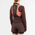 salomon active skin 4, lightweight breathable hydration running vest, woman wearing a dark grey running vest with orange details back view