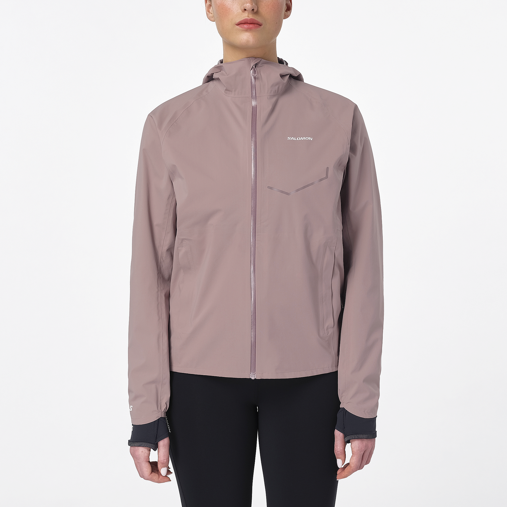 Woman wearing the salomon bonatti waterproof jacket, in antler colour, showing taped zip on front and salomon logo