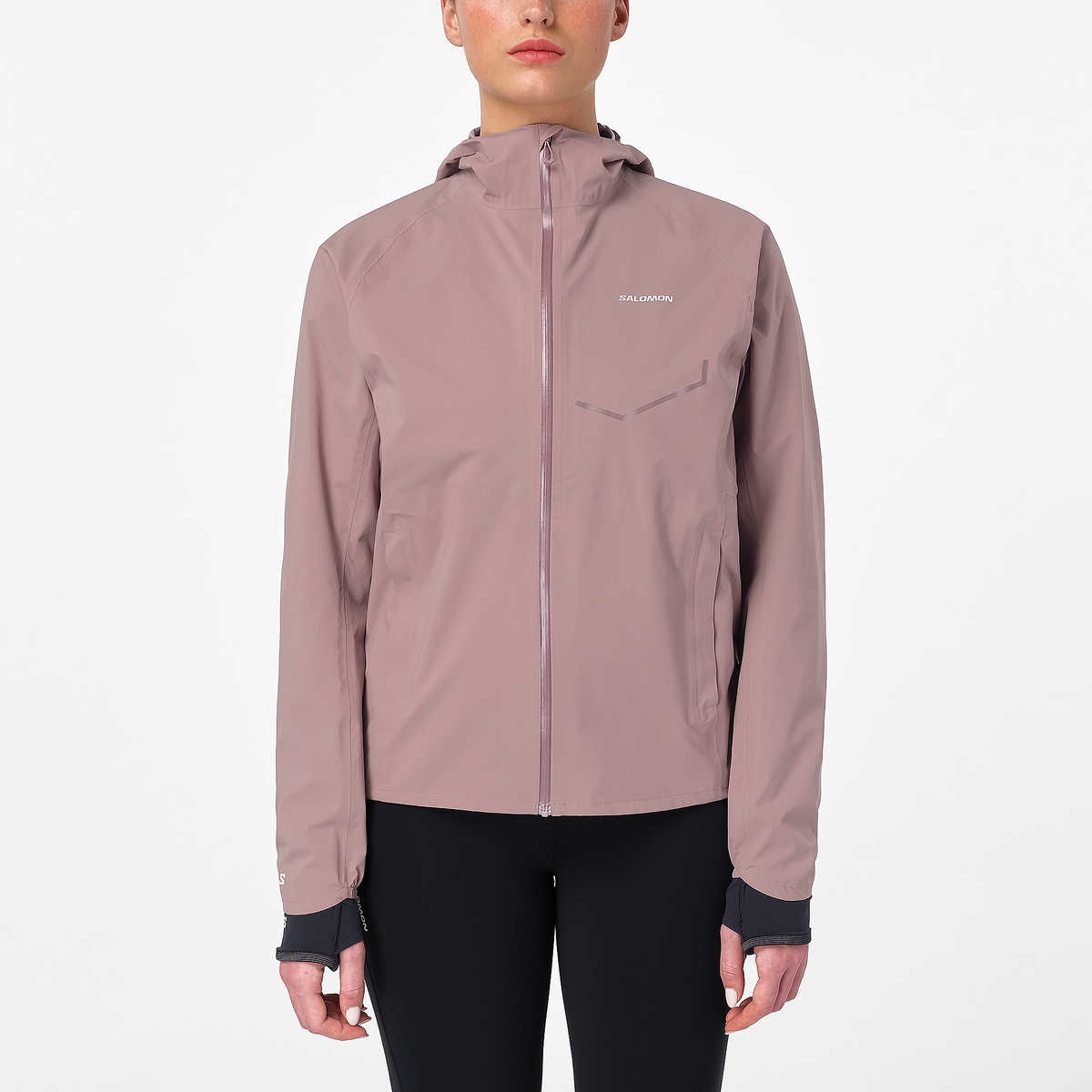 Woman wearing the salomon bonatti waterproof jacket, in antler colour, showing taped zip on front and salomon logo