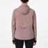 Woman wearing the salomon bonatti waterproof jacket, in antler colour, showing back features including hood and draw string