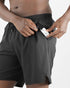 man wearing Salomon Shakeout Core 2in1 7" run short showing zip pocket holding headphones