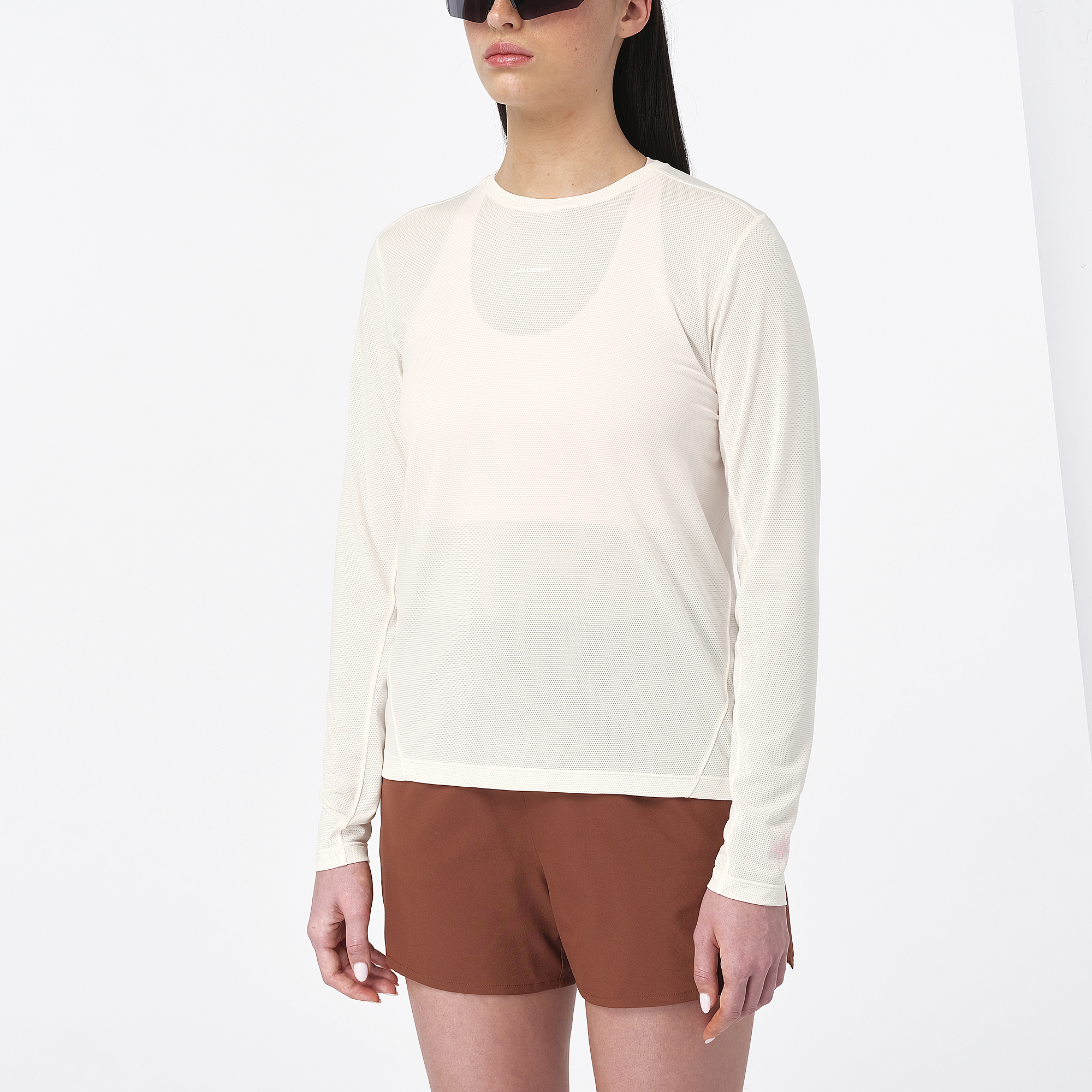 salomon womens shakeout core long sleeve, super breathable long sleeve shirt, white with light pink design, front of woman wearing long sleeve top
