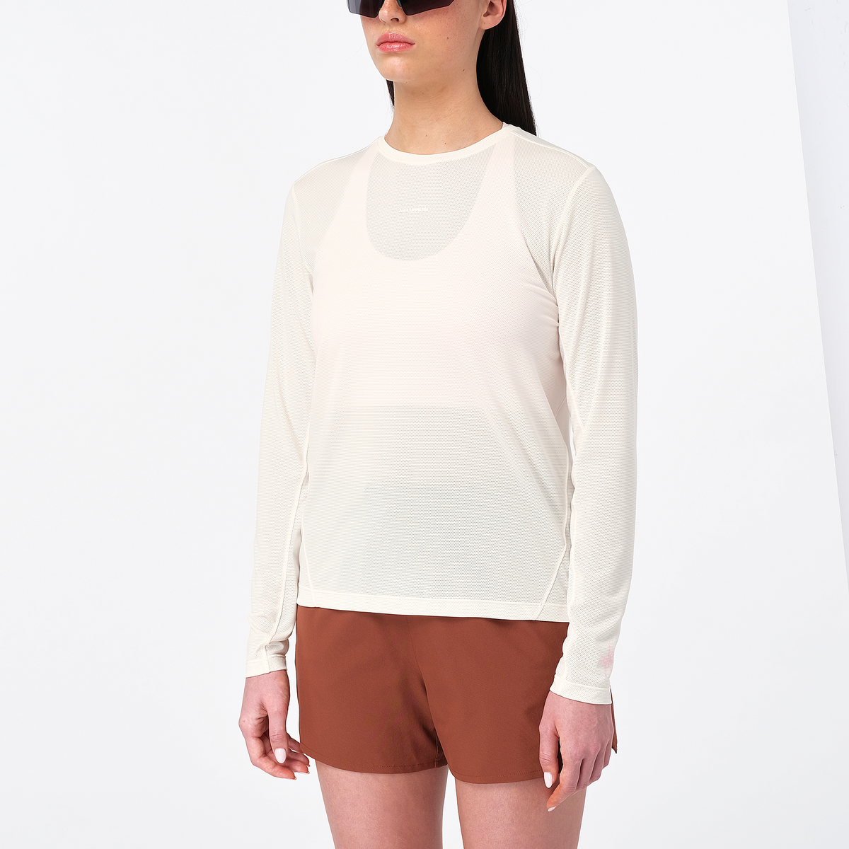 salomon womens shakeout core long sleeve, super breathable long sleeve shirt, white with light pink design, front of woman wearing long sleeve top