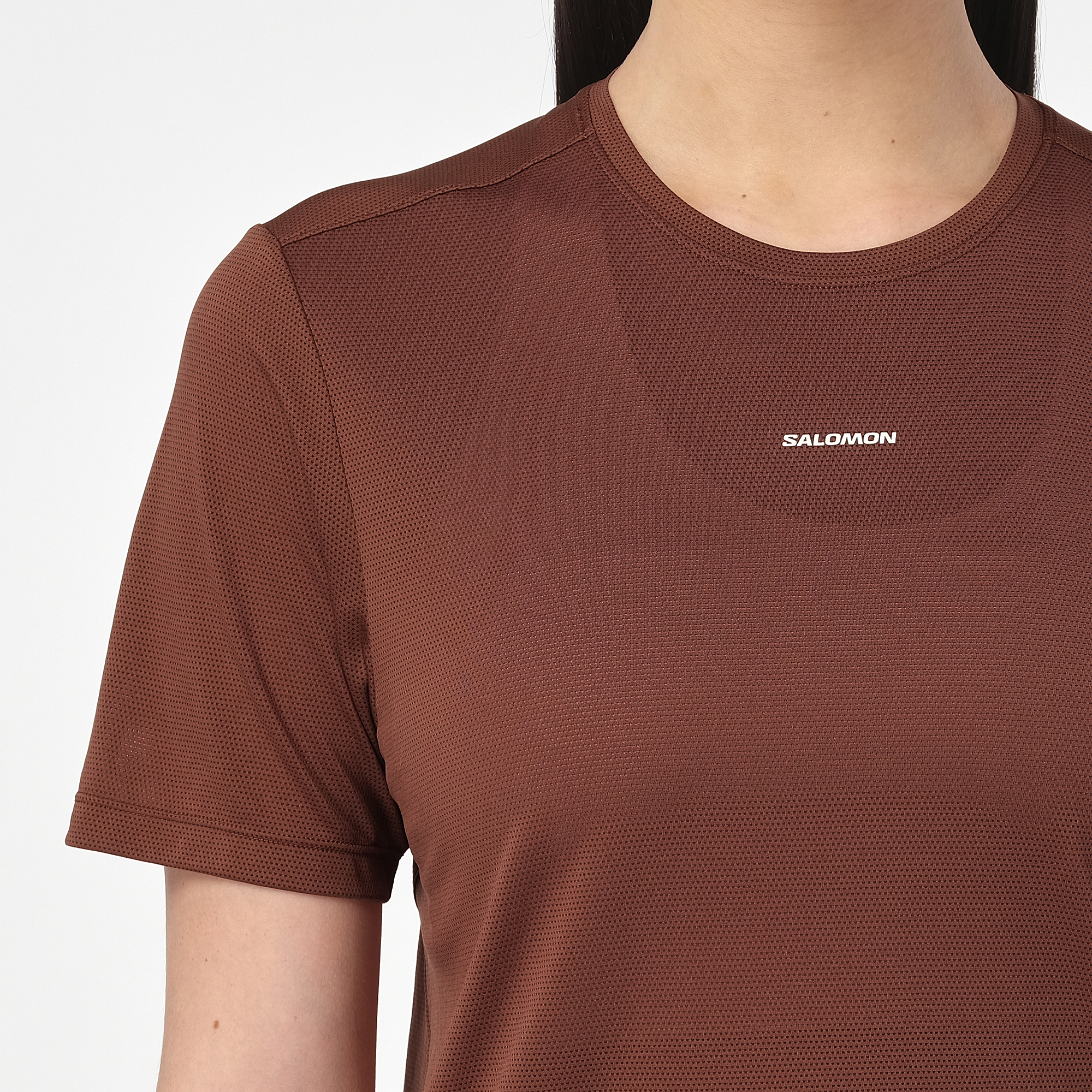 salomon shakeout core short sleeve running t-shirt for women, light and breathable run tee, dark burgundy colour with white salomon logo, close up of model wearing salomon tee on white background 