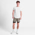 saysky pace 2-in-1 runnning short for men in taupe, comfortable running short with pockets, full body profile of man wearing saysky shorts and a white t-shirt