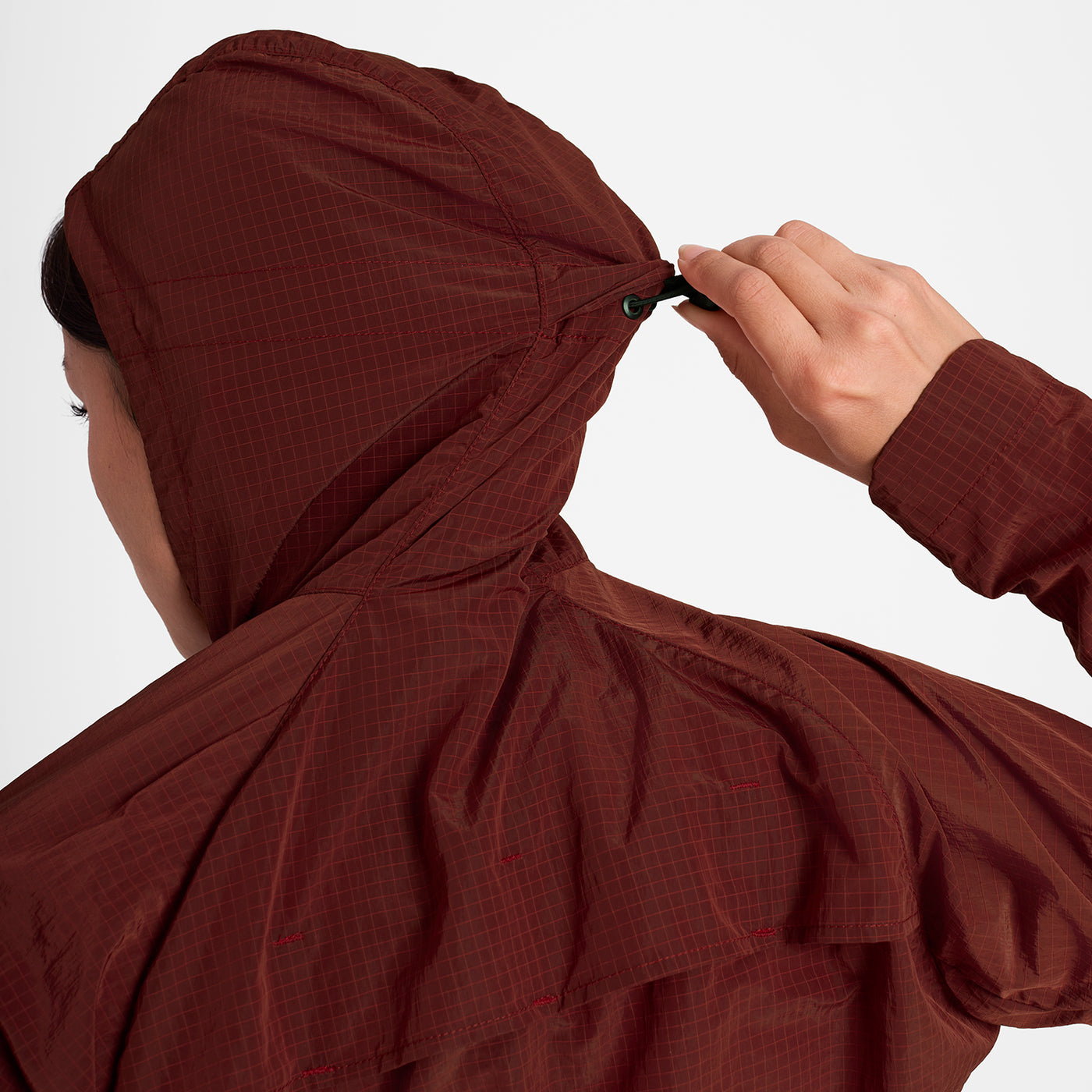 Woman wearing SAYSKY Clean Pace Shield Running Jacket in red colour, showing adjustable hood 