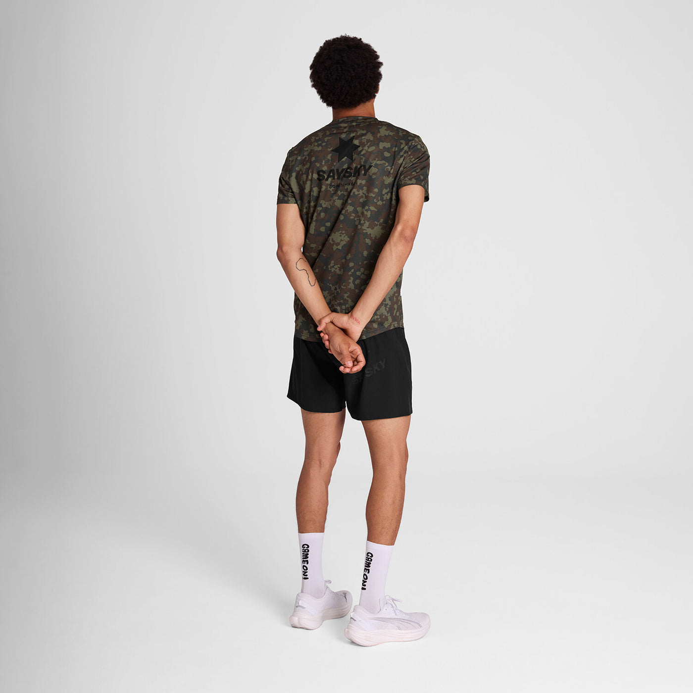 man wearing saysky camo combat tshirt, showing back