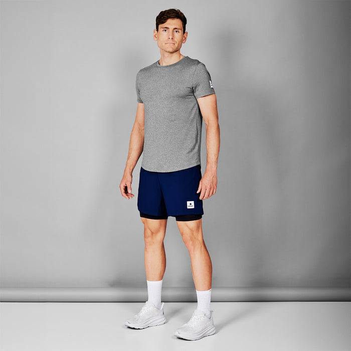 saysky short sleeve running t-shirt for men in grey, stretchy and quick-drying running tee, full body profile of man wearing saysky t-shirt and navy shorts