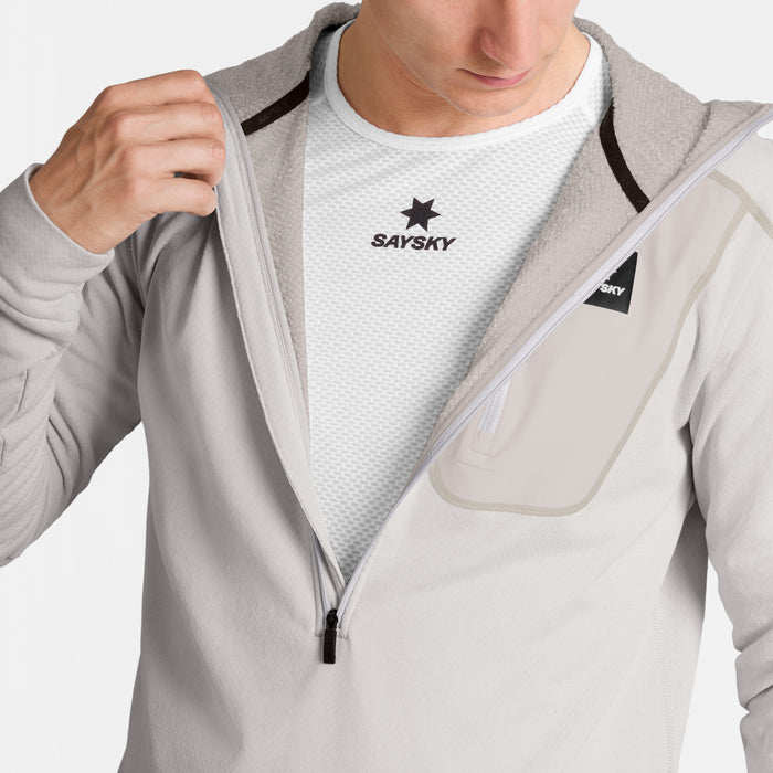 SAYSKY mens combat half zip fleece hoodie, warm and lightweight longsleeve fleece for running, grey colour with black SAYSKY logo, close up view of man wearing fleece with a white SAYSKY t-shirt underneath