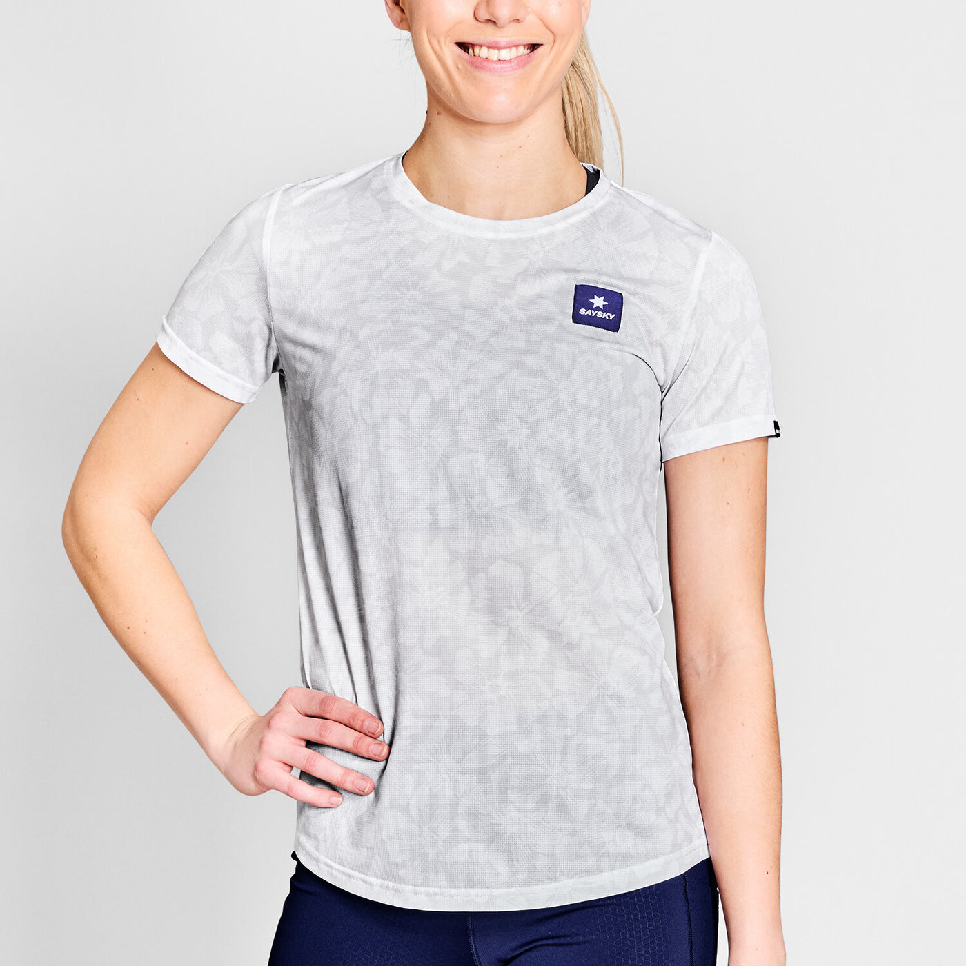 woman wearing saysky run tshirt with flower pattern and logo at front