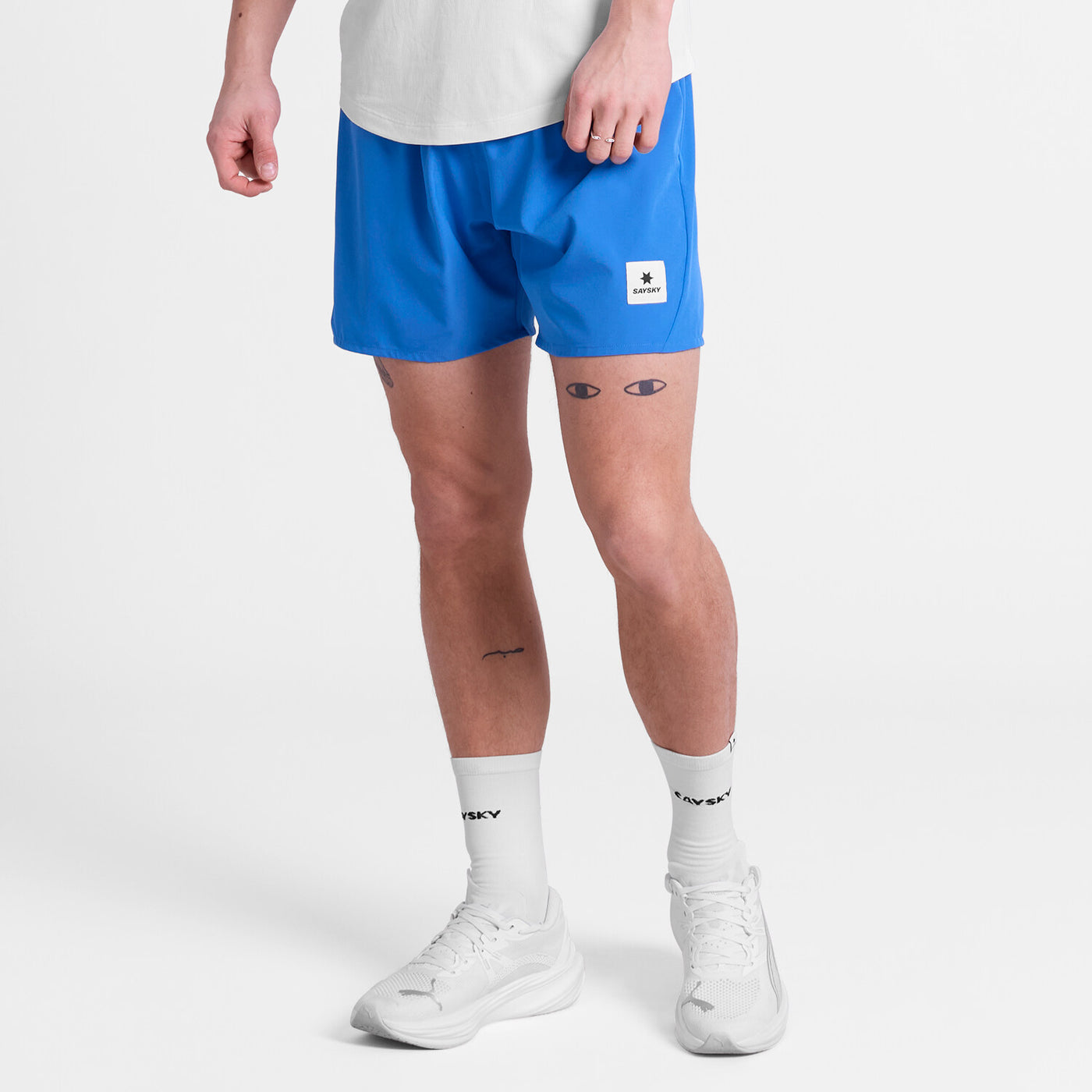 man wearing saysky pace 5 inch run shorts in blue colour with logo at front