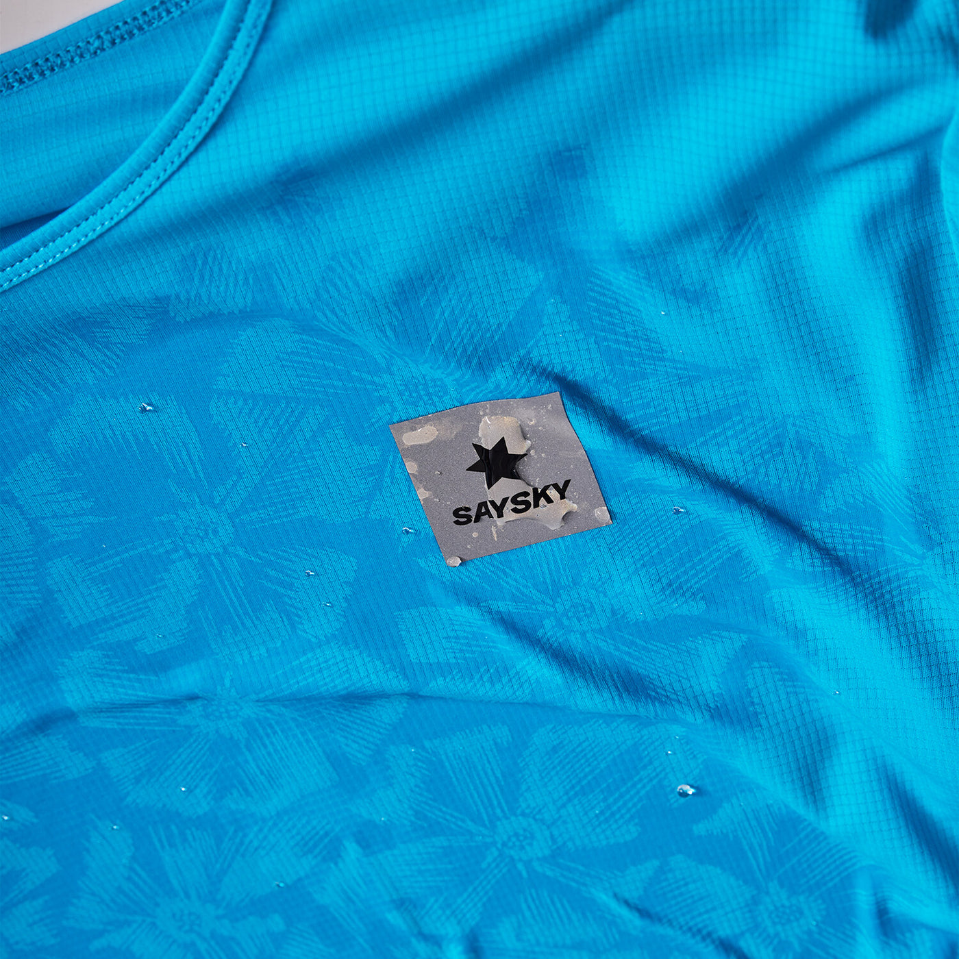 blue saysky singlet with reactive fabric that shows a flower pattern when wet