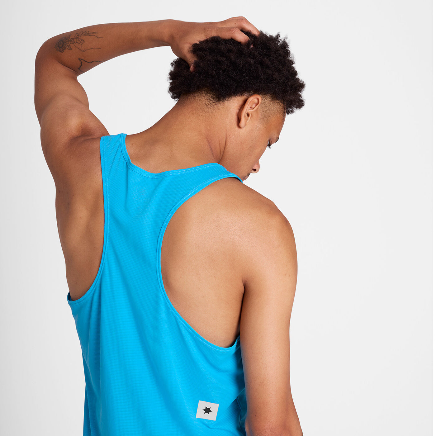 man wearing blue saysky singlet with reactive fabric that shows a flower pattern when wet
