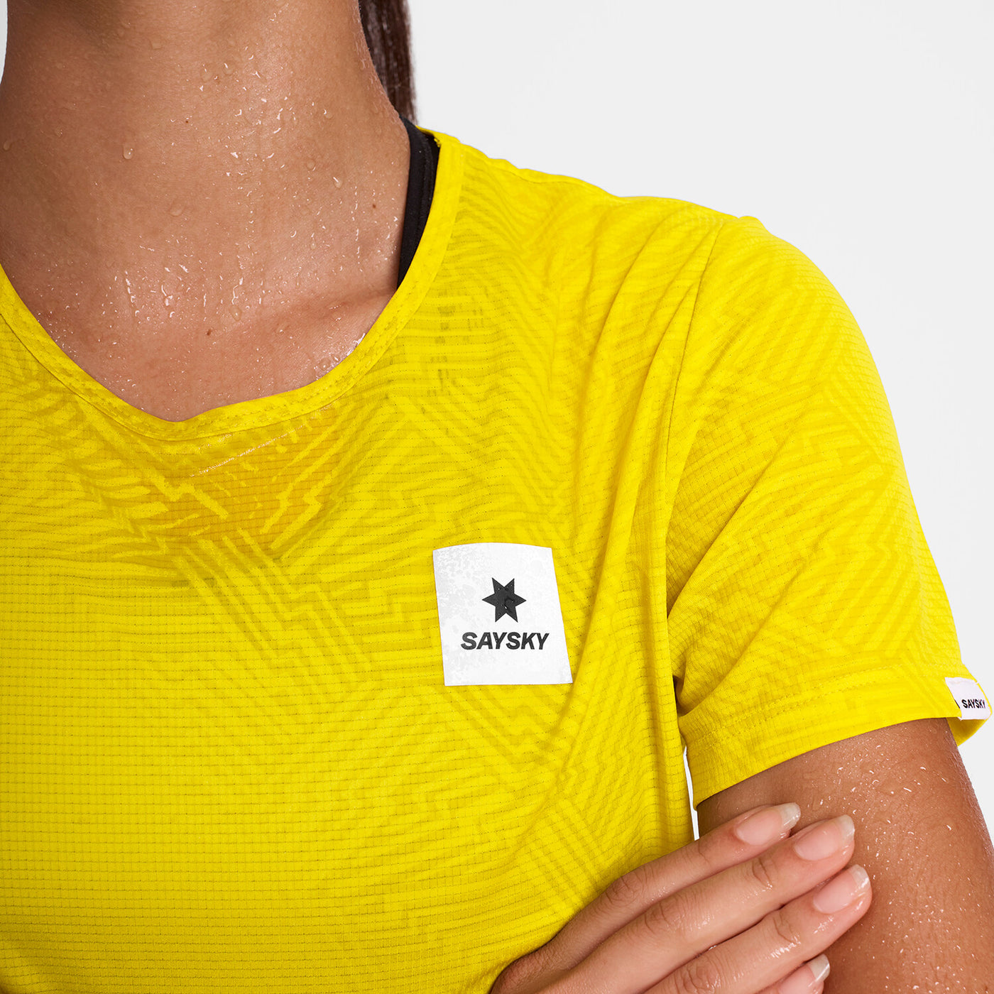 woman wearing saysky run tee in yellow colour, with logo at front