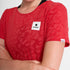 woman wearing saysky run tee in red colour, with logo at front, flower pattern shows when tee is wet