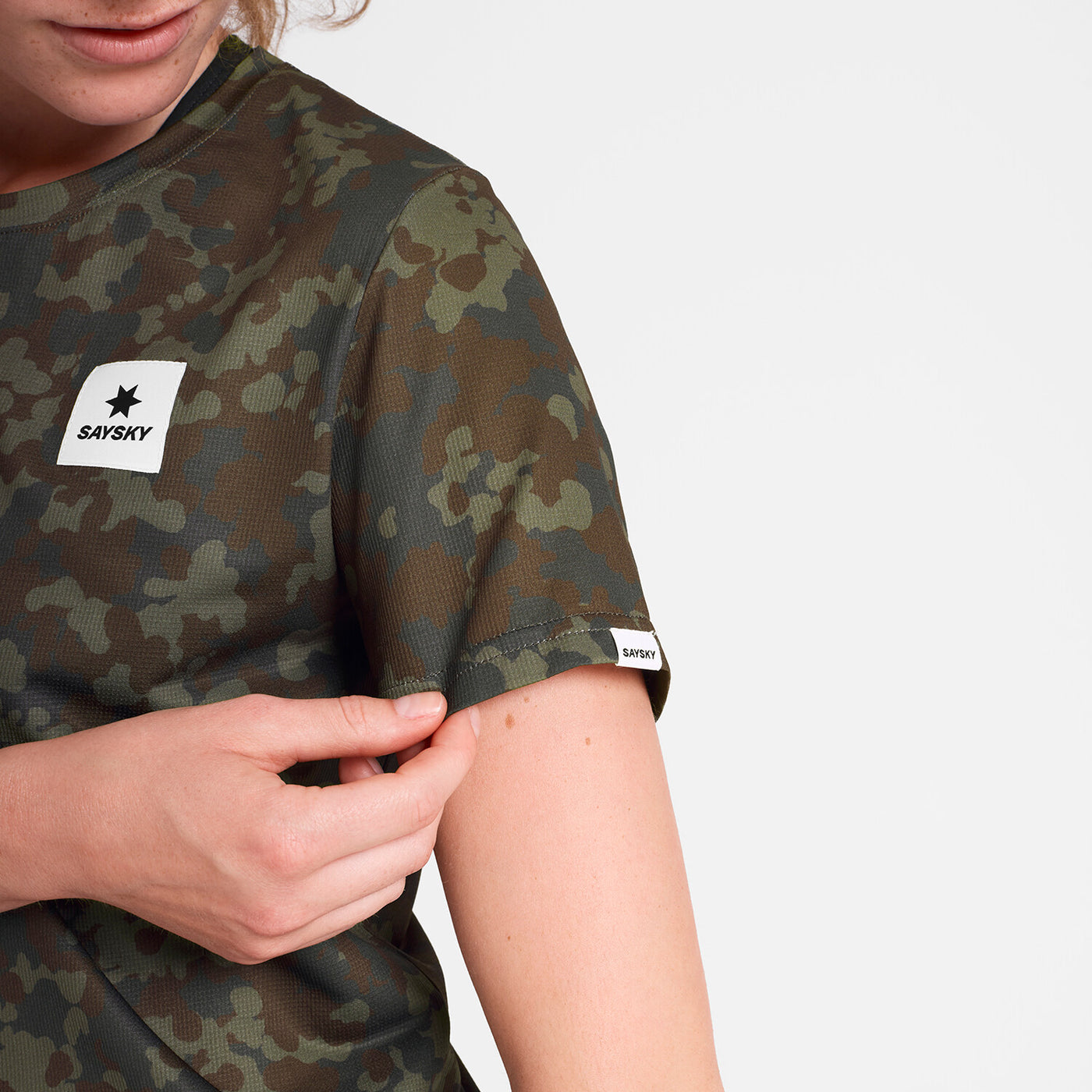 saysky lightweight running t-shirt for women, breathable and quick dry material,  brown and green camouflage colour, close up of woman wearing saysky t-shirt on a white background