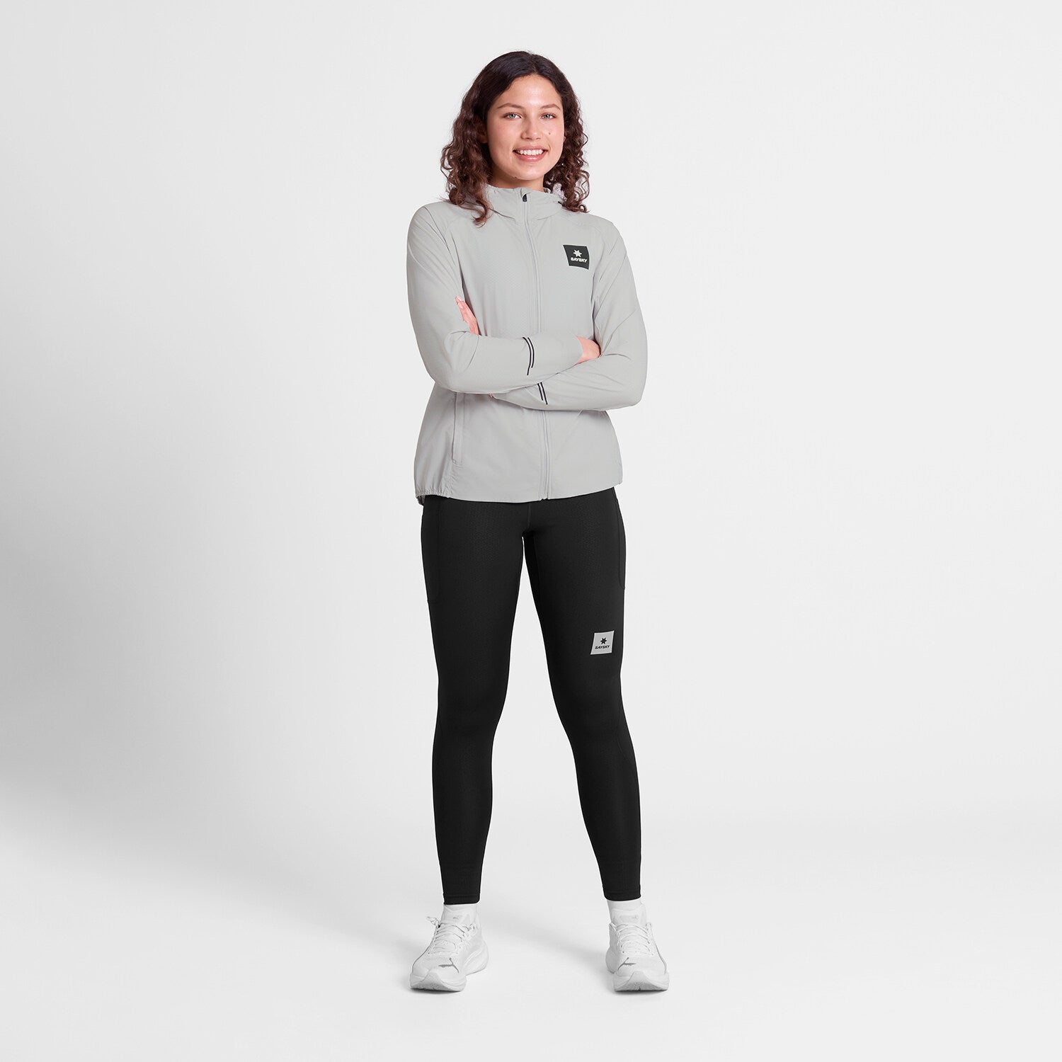 saysky womens pace flex hooded jacket sleeve, Wind-resistant, breathable jacket for running, light grey colour, full body shot of woman wearing saysky grey jacket and black leggings