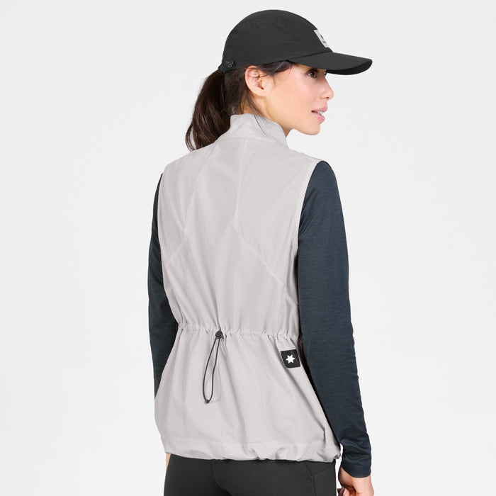 SAYSKY womens clean pace flex vest, lightweight, windproof zip-up running vest for women, grey colour with black SAYSKY logo, back profile of women wearing vest with black longsleeve and cap on a white background