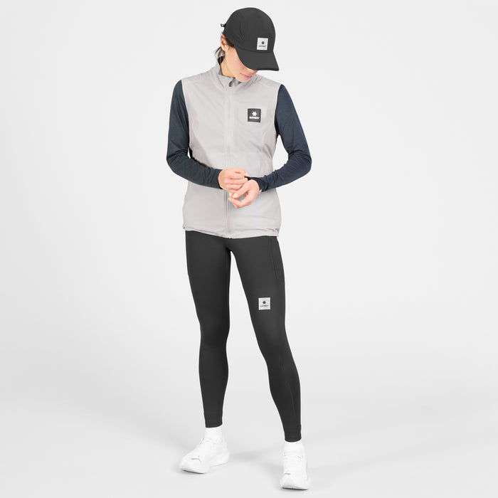 SAYSKY womens clean pace flex vest, lightweight, windproof zip-up running vest for women, grey colour with black SAYSKY logo, full body shot of women wearing vest with black longsleeve and cap on a white background