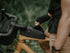 black topeak fast fuel bag bolt on, small compact top loading cycling bag, bag on mountain bike with person taking out phone from bag