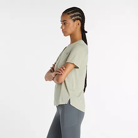 new balance short sleeve shirt for women, lightweight breathable tshirt, light green colour, side profile of woman wearing shirt with small side slit
